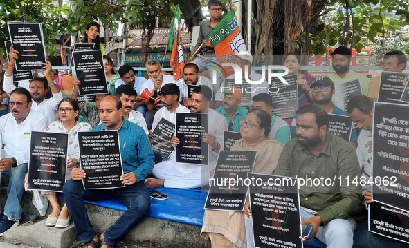 Bharatiya Janata Party (BJP) supporters, along with Siliguri MLA Sankar Ghosh, are holding placards as they are participating in a protest t...