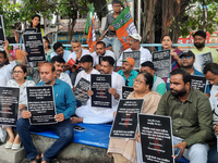 Bharatiya Janata Party (BJP) supporters, along with Siliguri MLA Sankar Ghosh, are holding placards as they are participating in a protest t...