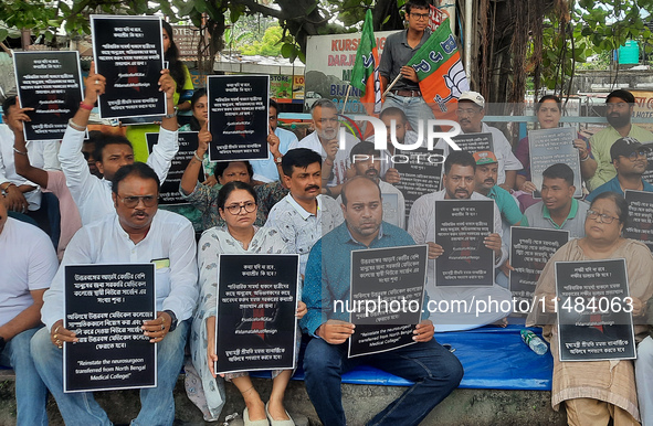 Bharatiya Janata Party (BJP) supporters, along with Siliguri MLA Sankar Ghosh, are holding placards as they are participating in a protest t...