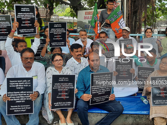 Bharatiya Janata Party (BJP) supporters, along with Siliguri MLA Sankar Ghosh, are holding placards as they are participating in a protest t...