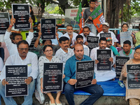 Bharatiya Janata Party (BJP) supporters, along with Siliguri MLA Sankar Ghosh, are holding placards as they are participating in a protest t...