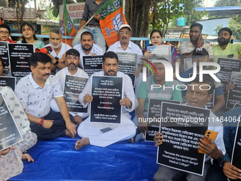 Bharatiya Janata Party (BJP) supporters, along with Siliguri MLA Sankar Ghosh, are holding placards as they are participating in a protest t...