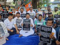 Bharatiya Janata Party (BJP) supporters, along with Siliguri MLA Sankar Ghosh, are holding placards as they are participating in a protest t...