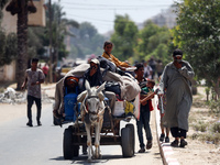 Palestinians are fleeing with their belongings in Deir el-Balah, in the central Gaza Strip, on August 16, 2024, amid the ongoing conflict be...