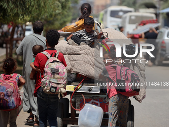 Palestinians are fleeing with their belongings in Deir el-Balah, in the central Gaza Strip, on August 16, 2024, amid the ongoing conflict be...