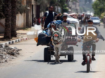 Palestinians are fleeing with their belongings in Deir el-Balah, in the central Gaza Strip, on August 16, 2024, amid the ongoing conflict be...