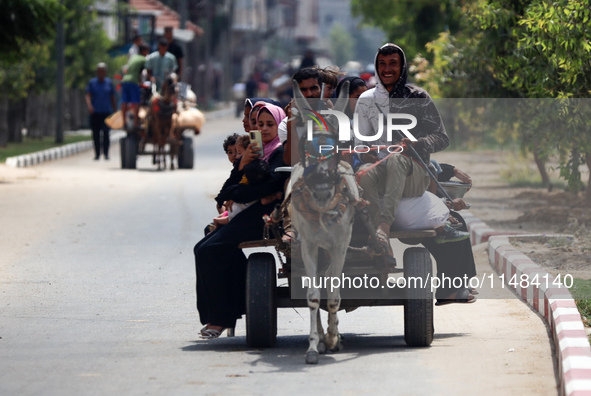 Palestinians are fleeing with their belongings in Deir el-Balah, in the central Gaza Strip, on August 16, 2024, amid the ongoing conflict be...