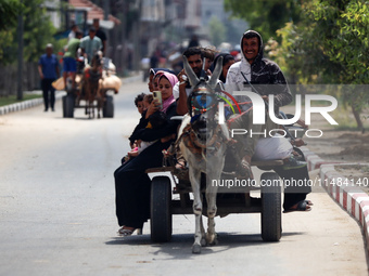 Palestinians are fleeing with their belongings in Deir el-Balah, in the central Gaza Strip, on August 16, 2024, amid the ongoing conflict be...