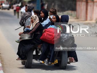 Palestinians are fleeing with their belongings in Deir el-Balah, in the central Gaza Strip, on August 16, 2024, amid the ongoing conflict be...