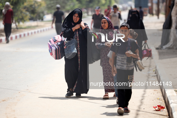 Palestinians are fleeing with their belongings in Deir el-Balah, in the central Gaza Strip, on August 16, 2024, amid the ongoing conflict be...