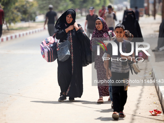 Palestinians are fleeing with their belongings in Deir el-Balah, in the central Gaza Strip, on August 16, 2024, amid the ongoing conflict be...