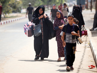 Palestinians are fleeing with their belongings in Deir el-Balah, in the central Gaza Strip, on August 16, 2024, amid the ongoing conflict be...