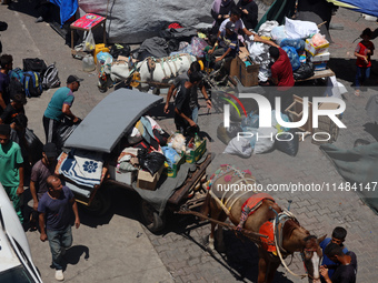 Palestinians are fleeing with their belongings in Deir el-Balah, in the central Gaza Strip, on August 16, 2024, amid the ongoing conflict be...