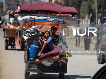 Palestinians are fleeing with their belongings in Deir el-Balah, in the central Gaza Strip, on August 16, 2024, amid the ongoing conflict be...