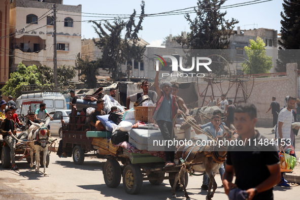 Palestinians are fleeing with their belongings in Deir el-Balah, in the central Gaza Strip, on August 16, 2024, amid the ongoing conflict be...