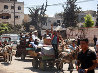 Palestinians are fleeing with their belongings in Deir el-Balah, in the central Gaza Strip, on August 16, 2024, amid the ongoing conflict be...