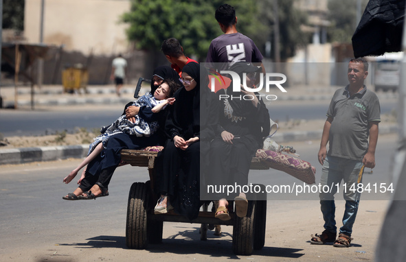 Palestinians are fleeing with their belongings in Deir el-Balah, in the central Gaza Strip, on August 16, 2024, amid the ongoing conflict be...