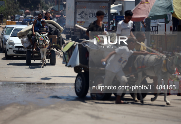 Palestinians are fleeing with their belongings in Deir el-Balah, in the central Gaza Strip, on August 16, 2024, amid the ongoing conflict be...