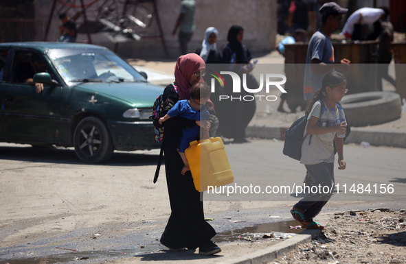 Palestinians are fleeing with their belongings in Deir el-Balah, in the central Gaza Strip, on August 16, 2024, amid the ongoing conflict be...