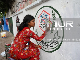 Students are painting graffiti on a wall alongside a road to express their message after the fall of Bangladesh's former Prime Minister Shei...