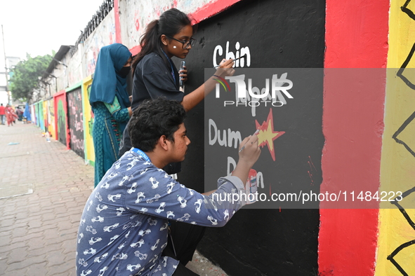 Students are painting graffiti on a wall alongside a road to express their message after the fall of Bangladesh's former Prime Minister Shei...