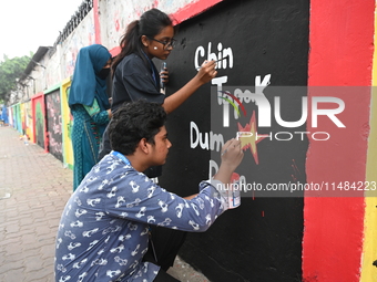 Students are painting graffiti on a wall alongside a road to express their message after the fall of Bangladesh's former Prime Minister Shei...