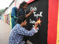 Students are painting graffiti on a wall alongside a road to express their message after the fall of Bangladesh's former Prime Minister Shei...