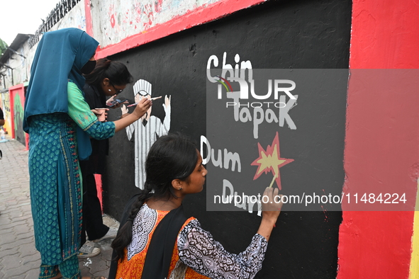 Students are painting graffiti on a wall alongside a road to express their message after the fall of Bangladesh's former Prime Minister Shei...