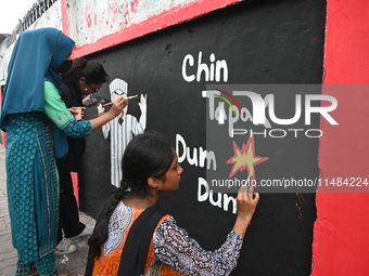 Students are painting graffiti on a wall alongside a road to express their message after the fall of Bangladesh's former Prime Minister Shei...