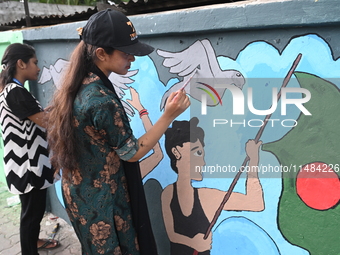 Students are painting graffiti on a wall alongside a road to express their message after the fall of Bangladesh's former Prime Minister Shei...