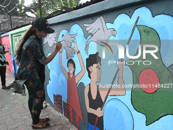 Students are painting graffiti on a wall alongside a road to express their message after the fall of Bangladesh's former Prime Minister Shei...