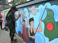 Students are painting graffiti on a wall alongside a road to express their message after the fall of Bangladesh's former Prime Minister Shei...