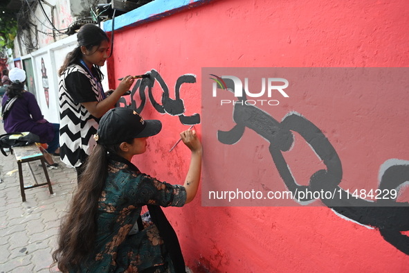 Students are painting graffiti on a wall alongside a road to express their message after the fall of Bangladesh's former Prime Minister Shei...