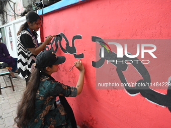 Students are painting graffiti on a wall alongside a road to express their message after the fall of Bangladesh's former Prime Minister Shei...