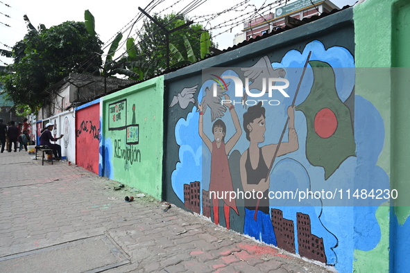 Students are painting graffiti on a wall alongside a road to express their message after the fall of Bangladesh's former Prime Minister Shei...