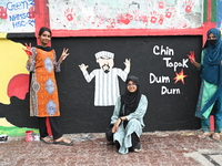 Students are showing their painted hands while painting graffiti on a wall alongside a road to express their message after the fall of Bangl...