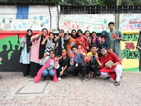 Students are showing their painted hands while painting graffiti on a wall alongside a road to express their message after the fall of Bangl...