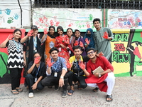 Students are showing their painted hands while painting graffiti on a wall alongside a road to express their message after the fall of Bangl...