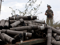 An armed soldier is standing behind a pile of used shells at the positions of the Motorised Rifle Battalion of the 93rd Kholodnyi Yar Separa...