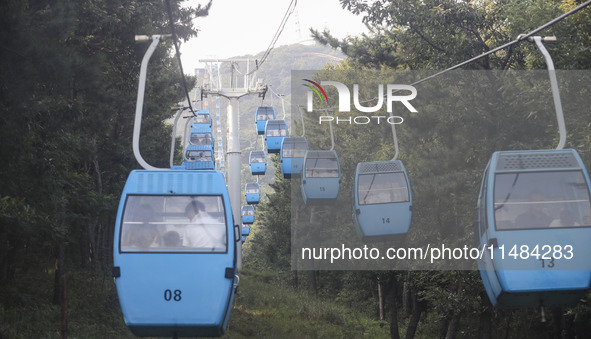 Tourists are riding ropeways at Lianhua Mountain in Dalian, China, on August 15, 2024. 