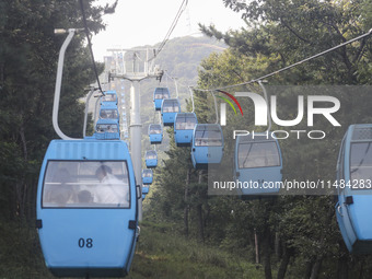 Tourists are riding ropeways at Lianhua Mountain in Dalian, China, on August 15, 2024. (