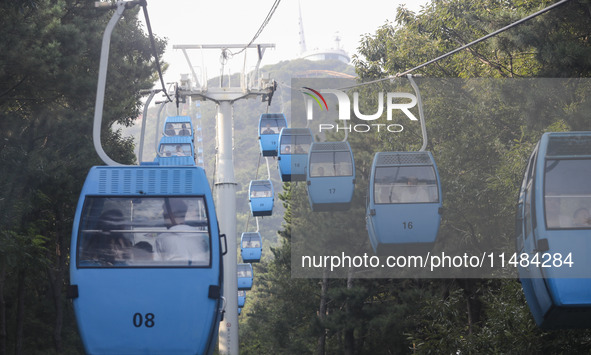 Tourists are riding ropeways at Lianhua Mountain in Dalian, China, on August 15, 2024. 