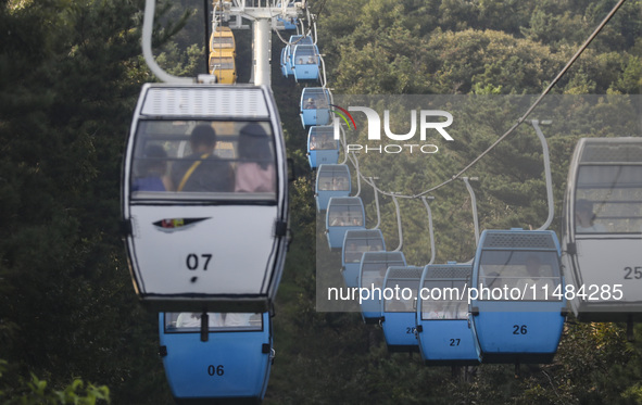 Tourists are riding ropeways at Lianhua Mountain in Dalian, China, on August 15, 2024. 