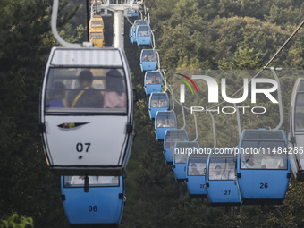 Tourists are riding ropeways at Lianhua Mountain in Dalian, China, on August 15, 2024. (