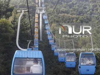 Tourists are riding ropeways at Lianhua Mountain in Dalian, China, on August 15, 2024. (