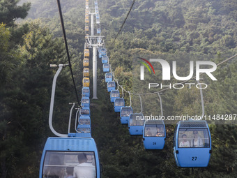 Tourists are riding ropeways at Lianhua Mountain in Dalian, China, on August 15, 2024. (