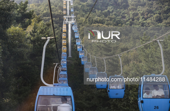 Tourists are riding ropeways at Lianhua Mountain in Dalian, China, on August 15, 2024. 