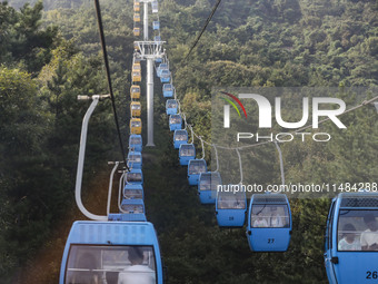 Tourists are riding ropeways at Lianhua Mountain in Dalian, China, on August 15, 2024. (