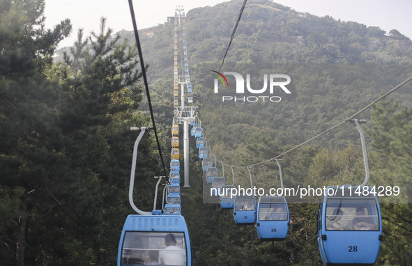 Tourists are riding ropeways at Lianhua Mountain in Dalian, China, on August 15, 2024. 