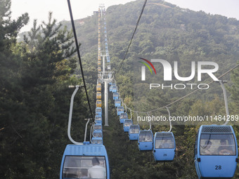 Tourists are riding ropeways at Lianhua Mountain in Dalian, China, on August 15, 2024. (